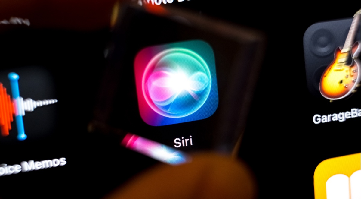 siri app icon on black smartphone screen, guitar on the right