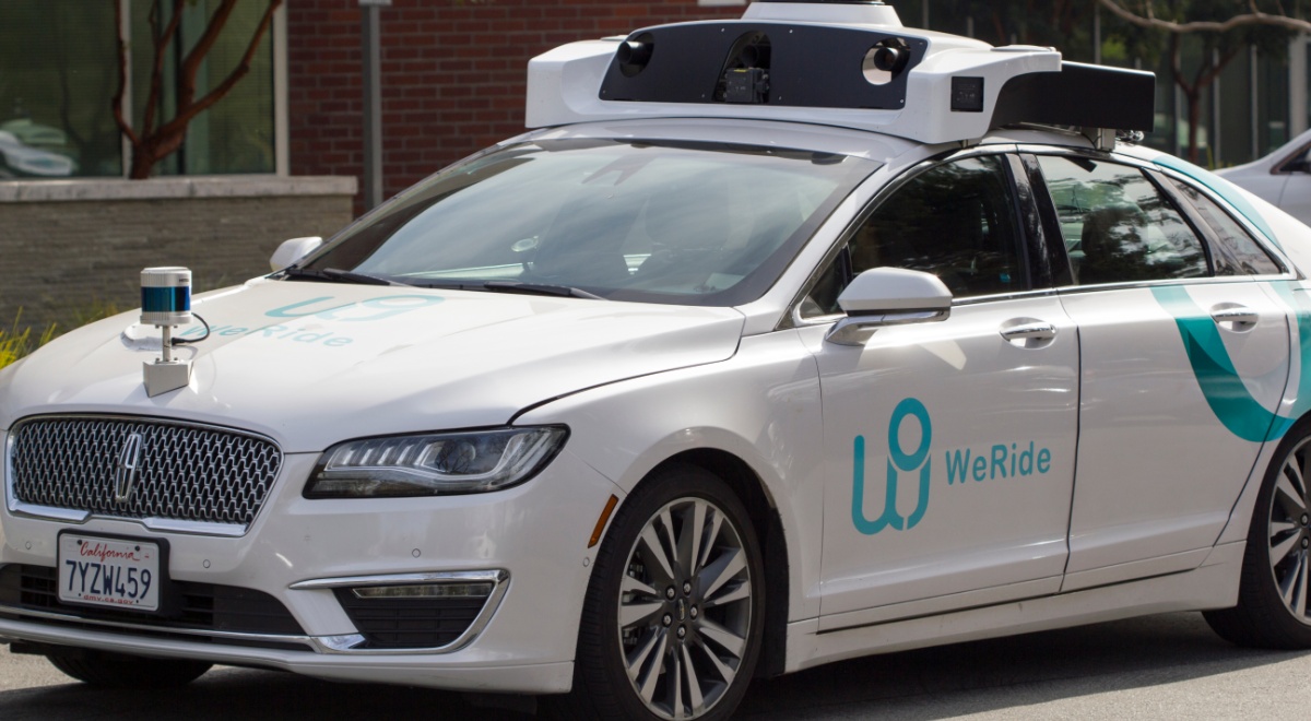silver car with baby blue weRide logo on left door