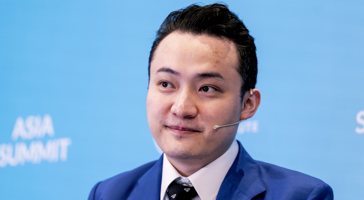 Justin Sun, dark blue suit, white collar shirt, white asian man, short dark hair, Asia summit