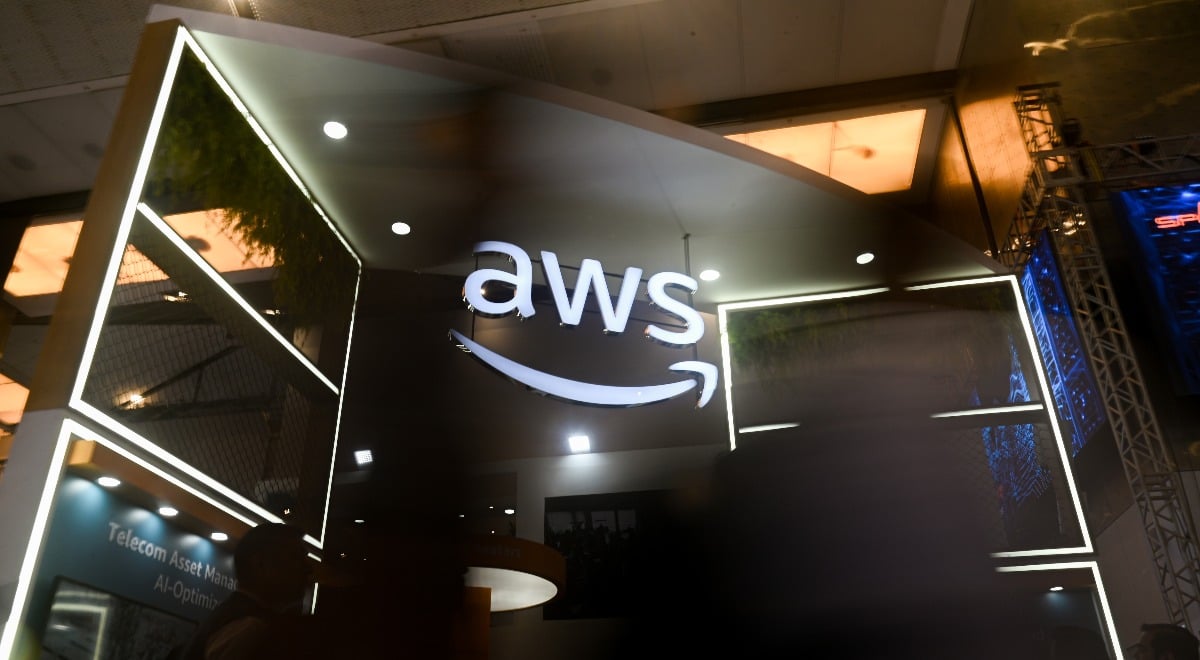 The Amazon Web Services (AWS) logo is visible at the India Mobile Congress 2025