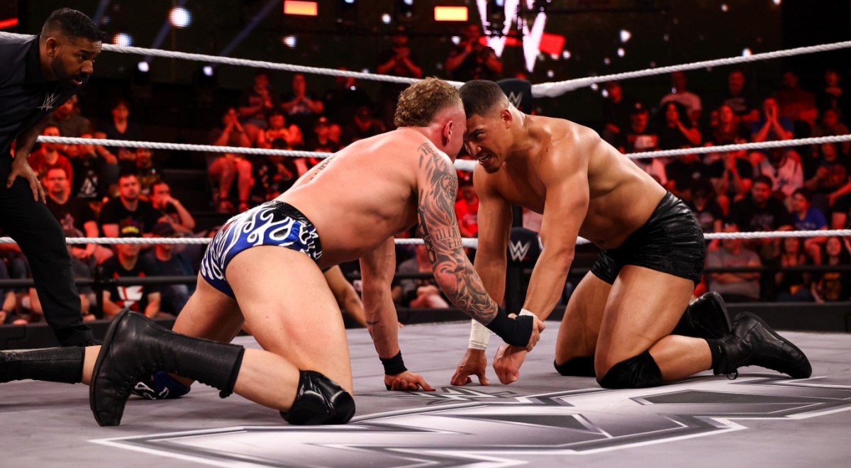 Wrestlers butting heads in the ring.