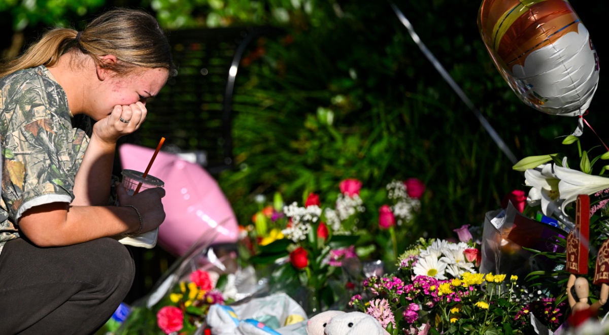 dark blonde sobbing, pink ballloon, ground full of flowers, stuffed bunnies, trasparent drink cup