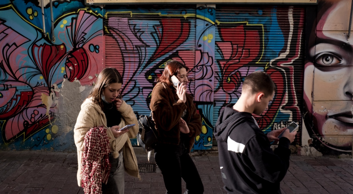 teenagers on phones, blue graffitti,