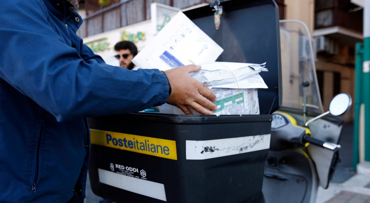Poste Italiane SpA postman, black box, white envelopes, blue jacket, black hair, male