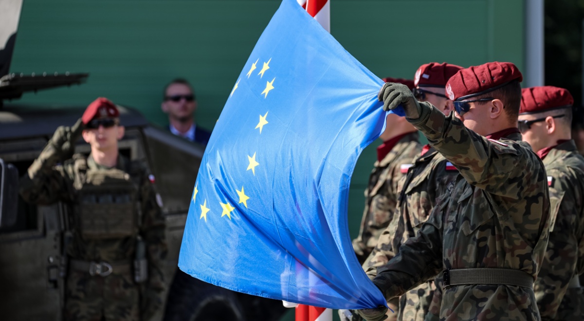 polish army men, war uniform, bordo hats, blue eu flag with yellow stars 
