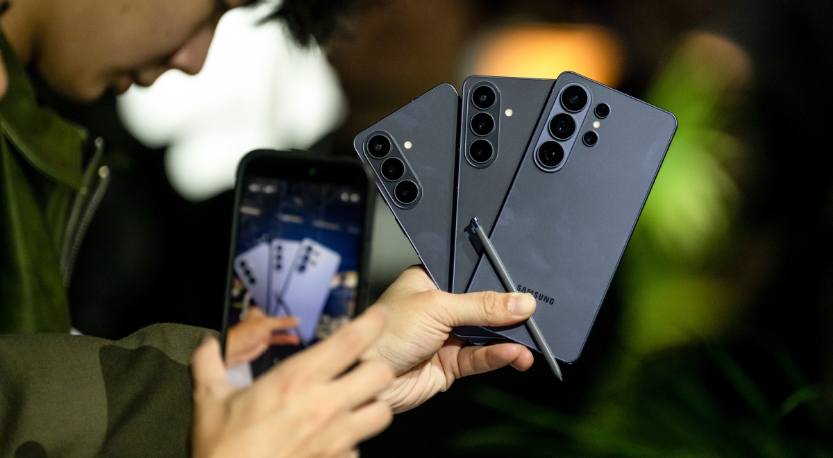 three black samsung galaxy  26S Ultra smartphones held in one hand, black pen, 