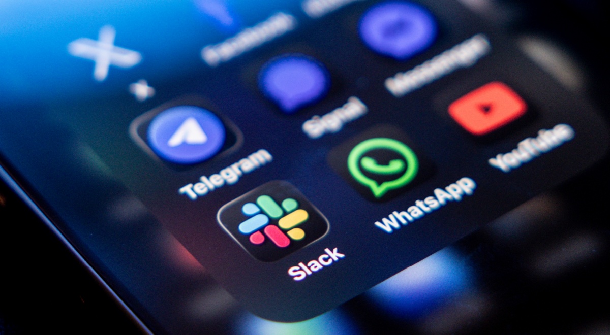 slack app icon next to whatsapp and telegram on dark smartphone screen