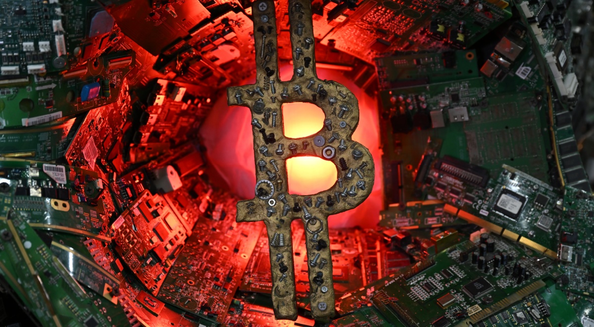 bitcoin logo made from spare metal parts or scrap metal, red light, green micro chips