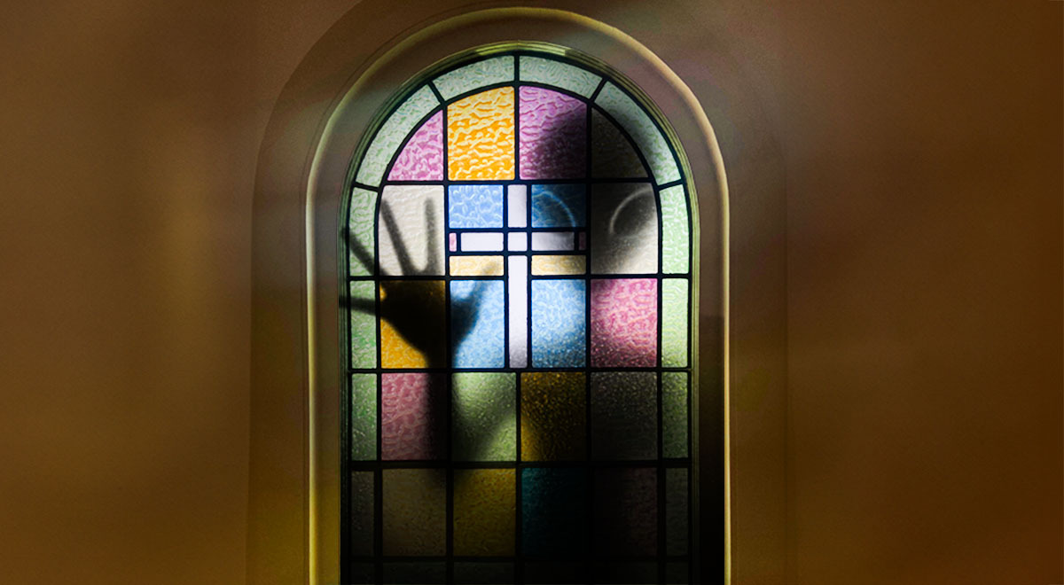 An alien silhouette pressing against a stained glass window.