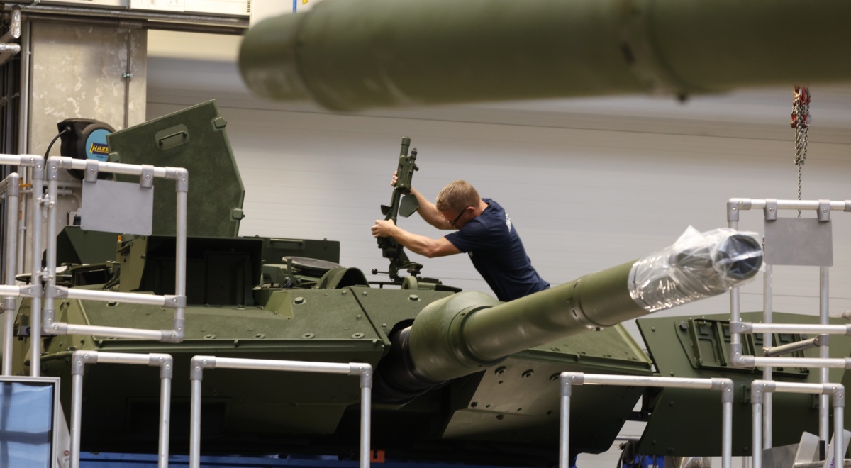 white man, machine gun, leopard 2A7 battle tank, indoors, blonde man