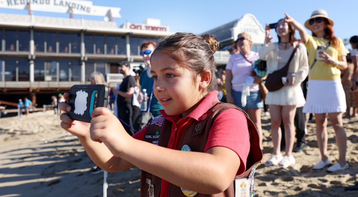 chubby girl scout, eight year old, dark pink t-shirt, vest, badges, beach, camera, people, sunny