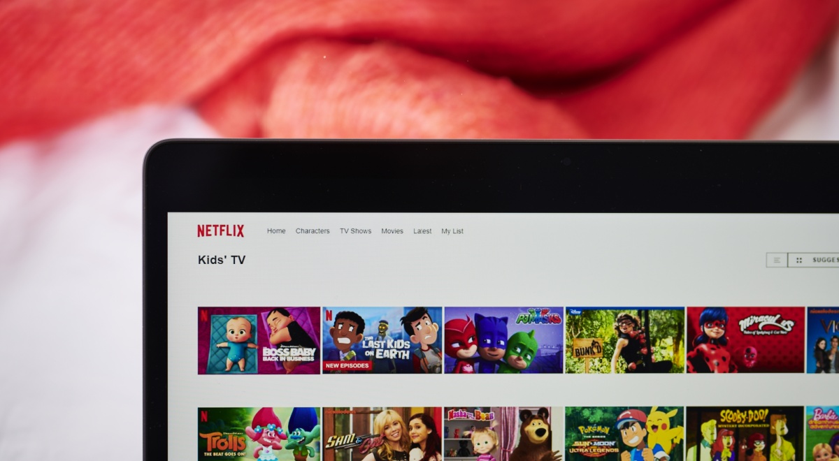 black laptop frame, white screen, netflix kids section, animated faces, red blanket