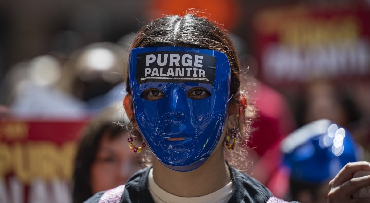 Anti-ICE demonstrator with mask saying "Purge Palantir"