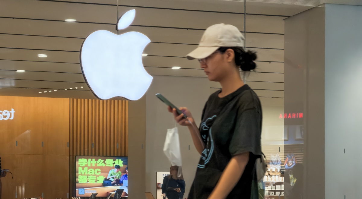 white asian woman ,sand color hat, black ponytail, apple logo