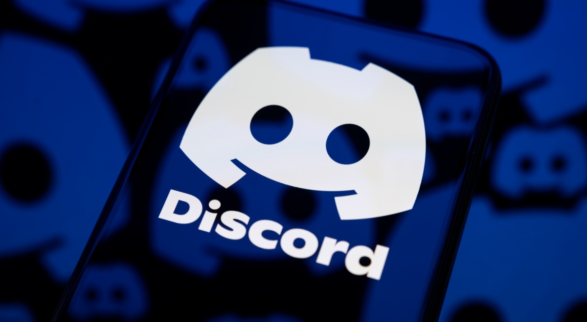dark smartphone screen reflects one big white discord logo, little darker ones are in the back