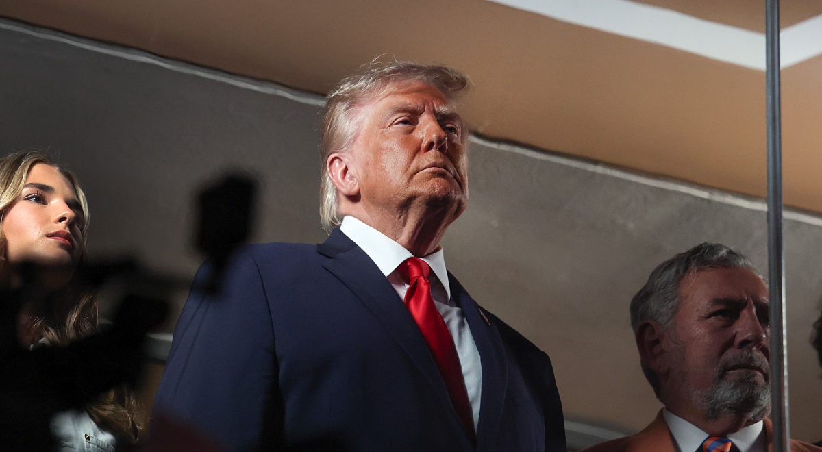 donald trump, black coat, white collar shirt, bright red tie, chin up, ivanka trump head in the left