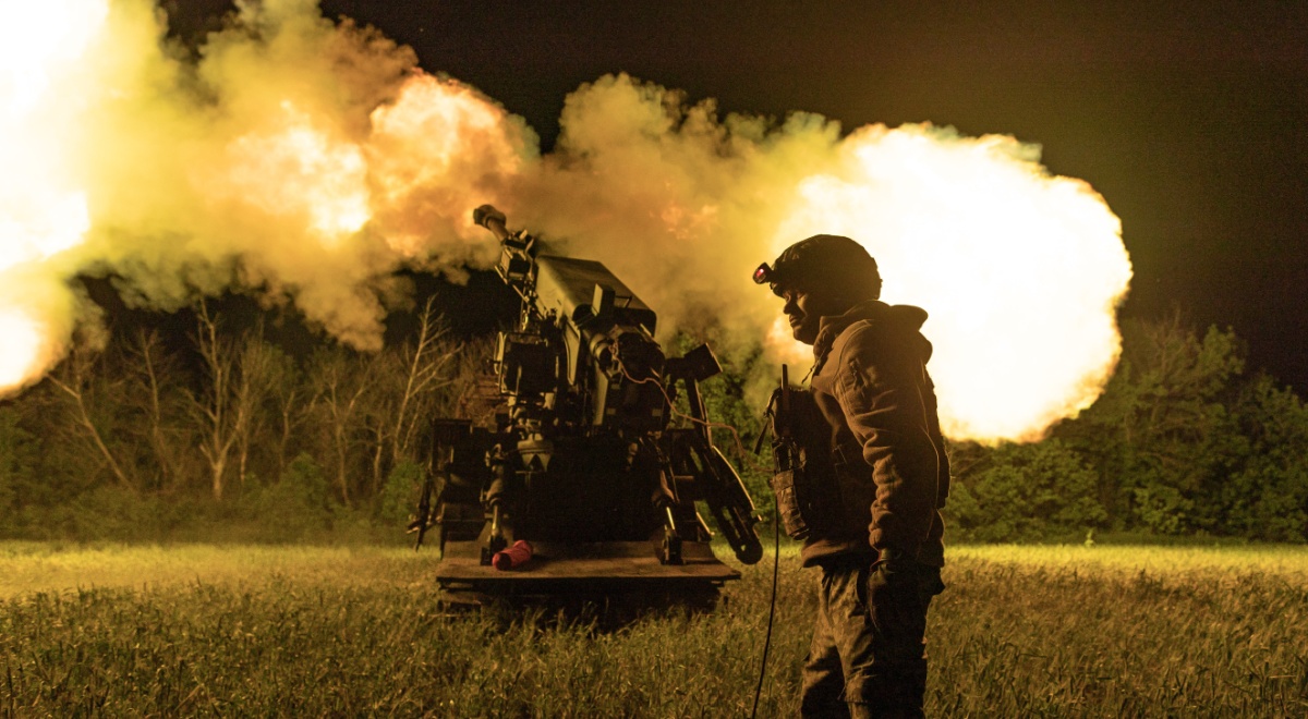 ukrianian soldier in uniform, helmet, white male, night time field, explosion artilery