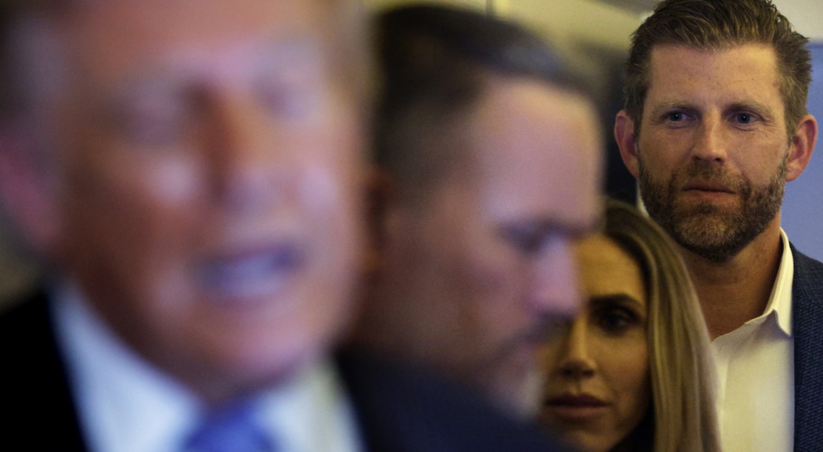 Eric Trump faded in the background behind President Trump and Melania, plus others.