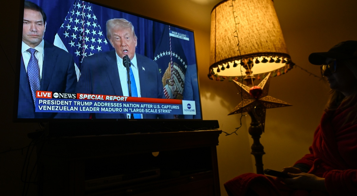 warm light floor lamp, donald trump on big tv screen, dark room, blue tie, white collar shirt