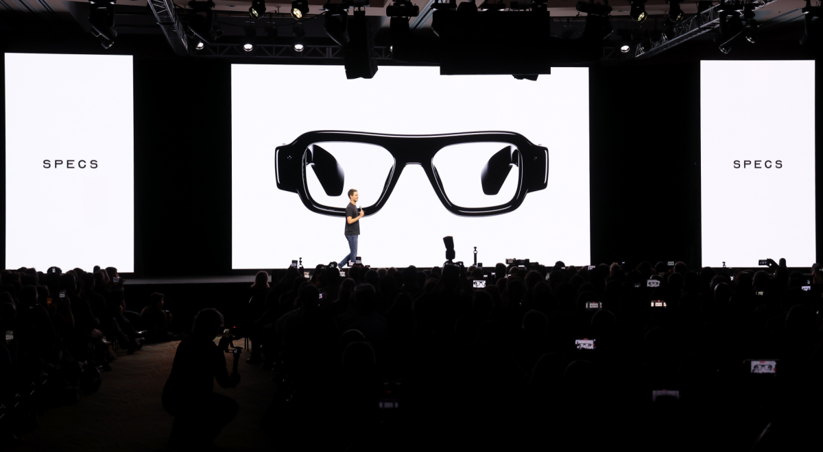 three huge white screens, black glasses, spiegel, white male in stage, black frames