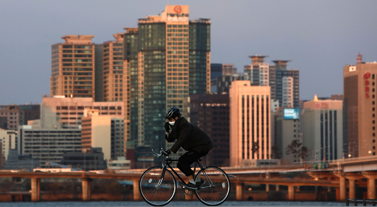 biker in seoul, tall buildings seen in the background