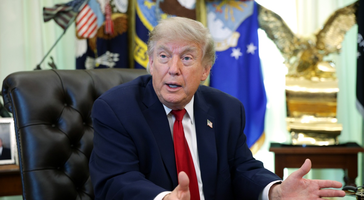 donald trump, dark suit, white collar shirt, dark red tie, usa flag pin, black leather chair