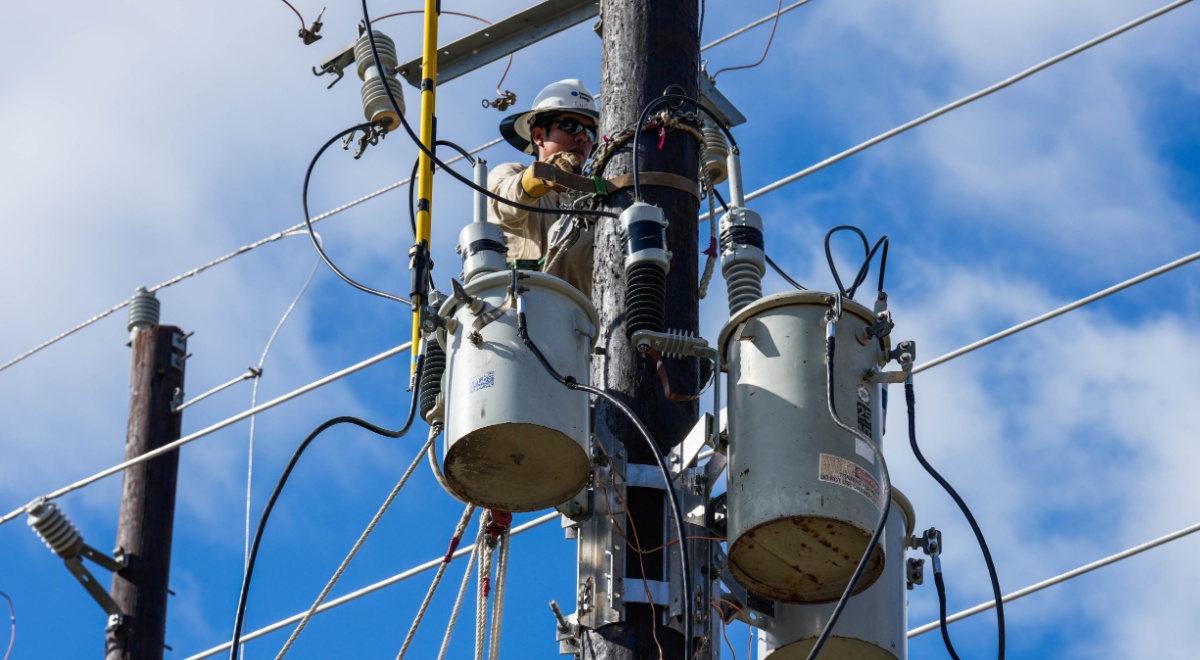 electricity wires, blue sky, wwhite cloud, man in helmet fixing transformer