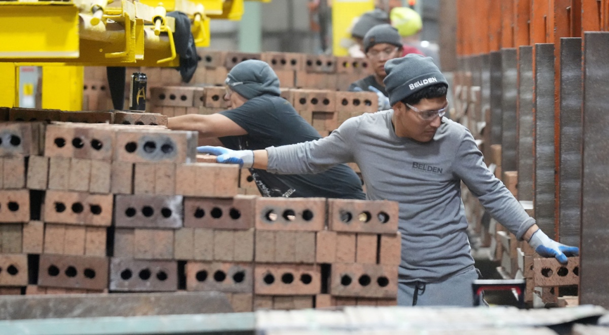 Workers package and cube pallet bricks, grey outfits