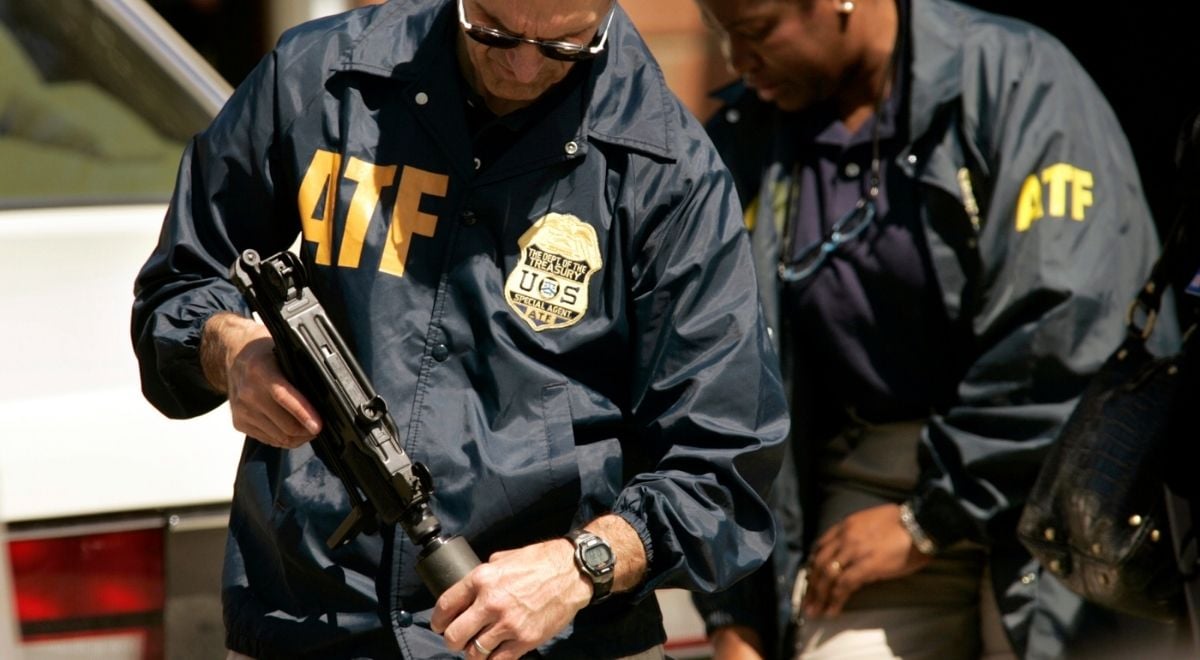 2 ATF agents wearing jackets with logo holding guns