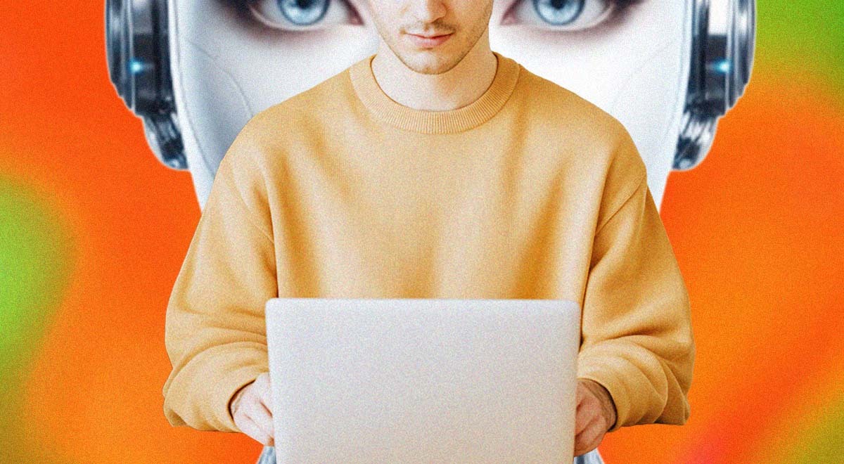 A person sitting at their laptop, big robot's head behind it
