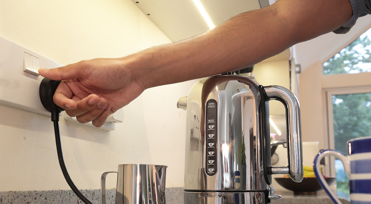 Person using electric kettle at home