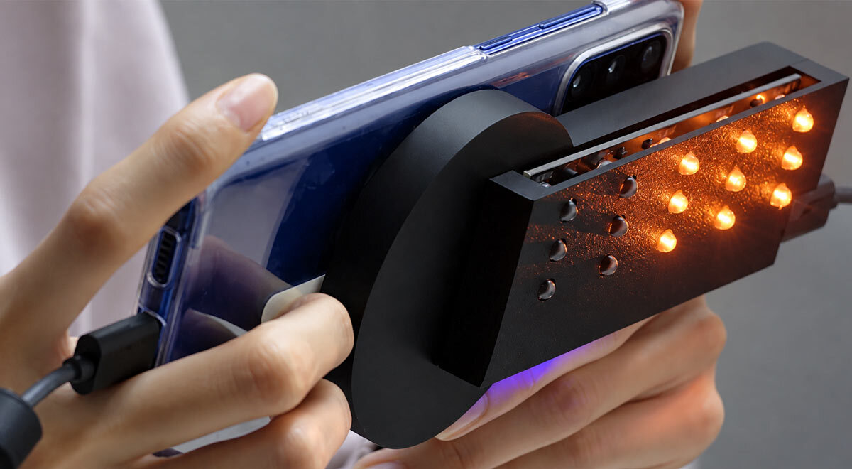 A hand holding a smartphone with SweepLED technology used to detect hidden cameras