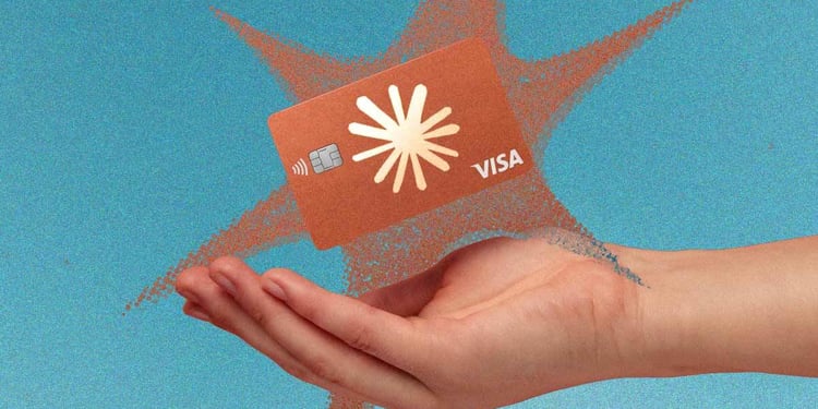 A hand holding a Visa card with Anthropic logo on it