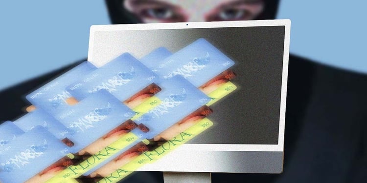Monitor with gift cards flying out of it with a hacker in the background.