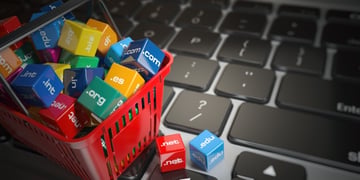 Shopping basket with domain names on computer keyboard