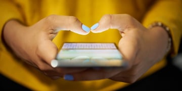 Young woman using cell phone to send text message on social network