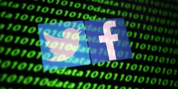 The Twitter and Facebook logo along with binary cyber codes are seen in this illustration