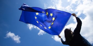 Person holding EU flag in the sky
