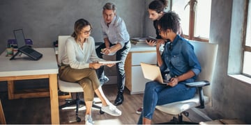 Diverse group of business people working together at a small office discussing a new business plan