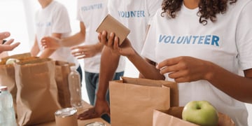Cropped shot of young volunteers group packing food and drinks for charity