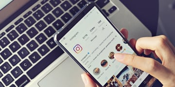 Woman holding smartphone with social internet service Instagram on the screen