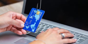 Phishing scam with credit card in fishing hook. Woman typing her credit card information on scam sit
