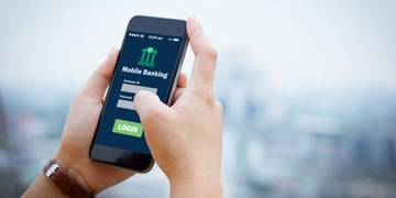 Female hands hold mobile banking on smart phone on blurred urban city as background