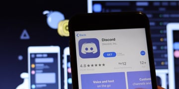Discord icon on phone screen with logo on blurry background