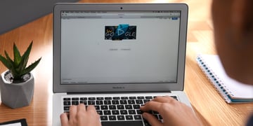 Person using Google search engine on MacBook Air laptop