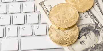 Bitcoins and dollars on the keyboard
