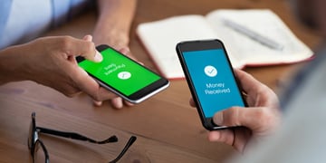 Closeup hands holding mobile phone with application for send and receive money.