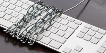 Keyboard wrapped in chain. Vigilante cybercrime concept