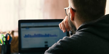 Man looking at chart on laptop