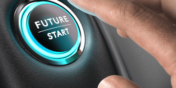 Finger reaching for Future/Start button in a car. Automotive industry breakout